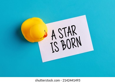 A Star Is Born Written On A Note Paper With A Rubber Toy Duckling On Blue Background. Newborn Baby Birth Announcement Or Celebration Message.