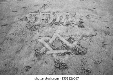 Star Of David Drawn On The Sand Beach In Tel Aviv, Israel And Over It The Name Of God In Hebrew (Jehovah) Is Written. Black White Photo.