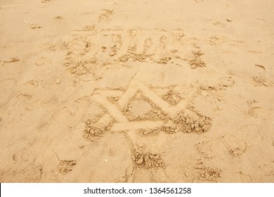 Star Of David Drawn On The Sand Beach In Tel Aviv, Israel And Over It The Name Of God In Hebrew (Jehovah) Is Written.