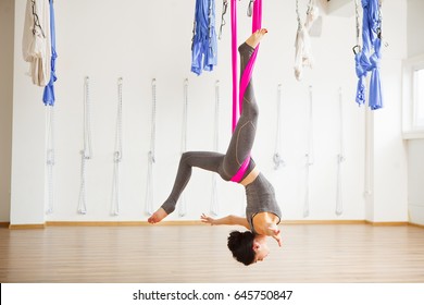 Star Inversion aerial antigravity yoga pose, woman exerciseses with hammock - Powered by Shutterstock