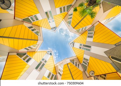 Star shapes formed where six Cube houses tilt into one another and intersect in Rotterdam, a quirky bright yellow architecturally unusual angular cube shape apartment block