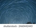 Star trail of stars moving in the night sky around the North Star. Landscape with movement of stars in the Tuscan country, time lapse