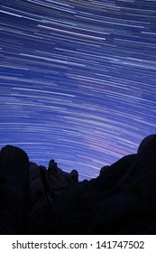 Star Trail Streaks Over The Rocks Of Joshua Tree Park