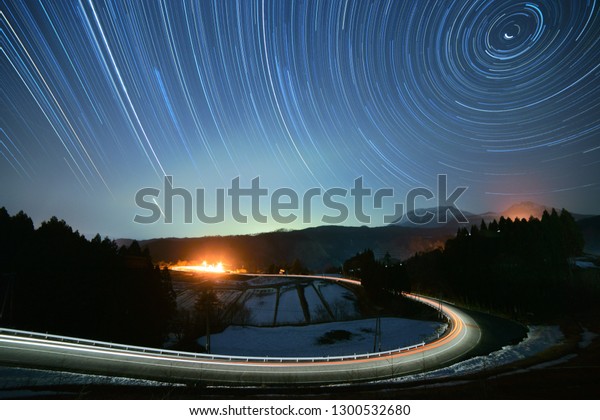 Star trails and a car light trail in the southern\
area of Mt. Daisen