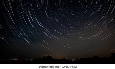 Star trails in the night sky. Stars move around a polar star - Powered by Shutterstock