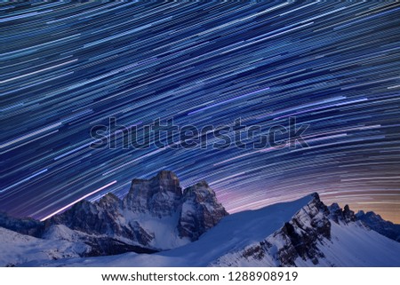 Star trails over the mountains, Dolomites, Italy. 
Beautiful spiral star trail at night. Fantastic star timelapse with mountain background.  Christmas time, Cortina Happy new year
