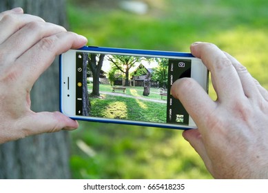 STARE SPLAVY, CZECH REPUBLIC - MAY 29, 2017: Photo Of A Photographer's Hands, Taking Photo Of A Park With His IPhone 7 Plus.