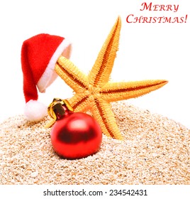 Starfish, Christmas Buable And Santa Claus Hat On The Sand Isolatd On White