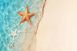 Starfish On The Sand Beach In Clear Sea Water. Summer Background. Summer Time .Copy Space. Relaxing On The Beach.