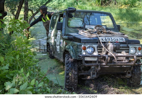 Stariy Oskol, Belgorod region / Russian\
Federation - august 10 2014: Local trophy raid \'Ublia-Trophy\' \
the\
crew of the car pulls out the car from the\
river