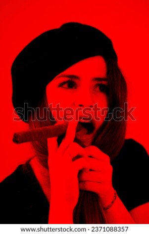 In stark black on red, a portrait emerges of a young woman, beret-clad, holding a cigar, reminiscent of iconic revolutionary imagery. The fervor of youth still untouched by life's mundane responsibili