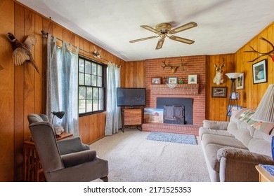 Starke, Florida USA - June 25, 2022: Living room with wood paneling and a wood burning fireplace