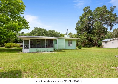Starke, Florida USA - June 25, 2022: Backyard of a single story home with a screened in patio