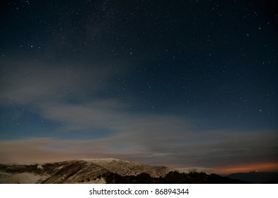 Starry cloudy sky in the mountains