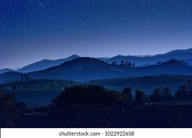 Starry Night With Beautiful Landscape View Of Hill Layers Against With Blue Night Sky