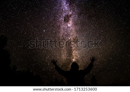 Starry night with milky way and girl silhouette is awe inspiring view of night sky at Hope Saddle in South Island of New Zealand