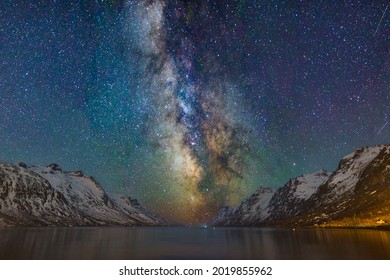 Starry night with the Milky Way in the sky along with snow capped mountains in the polar region of Norway - Powered by Shutterstock