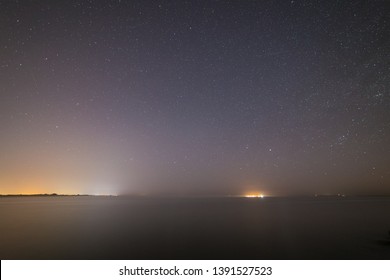 Starry Night On The Beach. Distant City Lights.