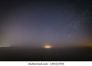 Starry Night On The Beach. Distant City Lights.