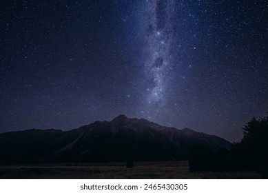 Starry Night Sky Above Mountain Range. The night sky is filled with countless stars shining above a majestic mountain range. The peaks of the mountains are silhouetted against the dark sky. - Powered by Shutterstock