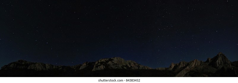 Starry Night Sky Above Rocky Cliffs. Natural Stars Panorama Photo