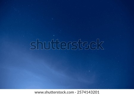 Starry night sky with clouds and constellations.