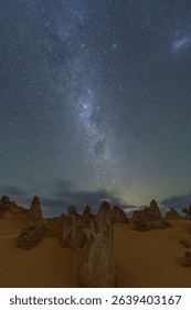 Starry night sky over Pinnacles Desert in Nambung National Park, Australia, featuring unique limestone formations and the Milky Way.