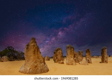 Starry sky above pillars of fossil plant remains The Pinnacles in Nambung National Park in Western Australia with golden yellow ornaments on the foreground against the sky of the Milky Way galaxy - Shutterstock ID 1969081285
