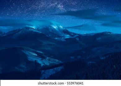 Starry sky with milky way in a sky above snow-capped peaks of the high mountain. Fantastic winter christmas night. The New Year's Eve. - Powered by Shutterstock