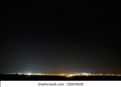 The Stars Of The Night Sky. City Street Light Illuminated. Urban Areas In The Starry Background.