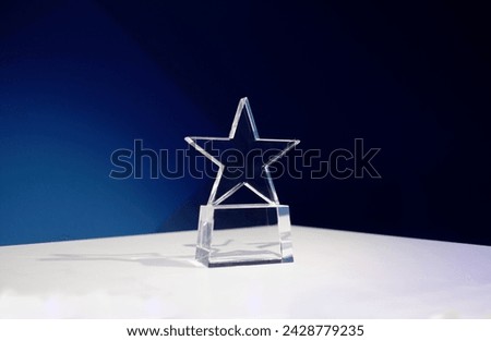 Star-shaped award on a table with spotlights and copy space