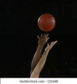 Start Of A Basketball Game With The Jump Ball As A White And Black Player Go For The Ball