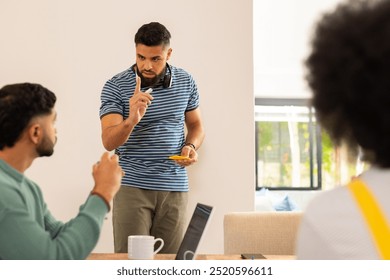 Start up business, Discussing ideas, young man gesturing while holding sticky notes with friends. Collaboration, brainstorming, teamwork, creativity, discussion, colleagues - Powered by Shutterstock