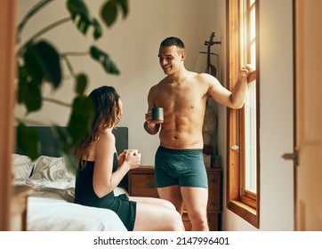 Start The Day With Your Favourite Person. Shot Of A Happy Young Couple Having Their Morning Coffee Together In The Bedroom At Home.