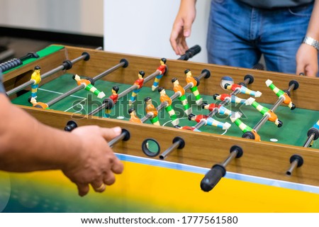 Start up Employee playing Table soccer in minkle area in the office