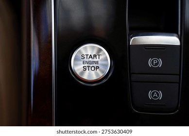 Start engine stop button on modern car dashboard with electronic parking brake and auto hold controls on center console.