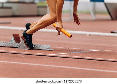 start female runner with baton in hand relay race running - Powered by Shutterstock