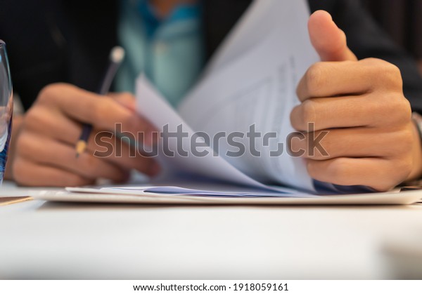 Start up learning for Document report business note\
in meeting room concept: Businessman manager hands writing for\
reading, signing in paperwork or documentation files at corporate\
on office desk