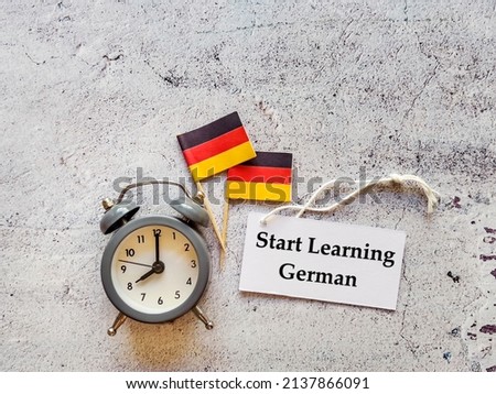 Start Learning  German Language  Education Concept with German flags ,alarm clock and message card 