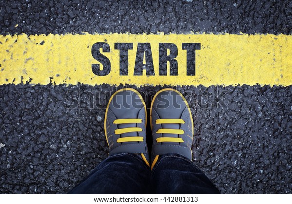 Start line child in sneakers standing next to a
yellow starting line