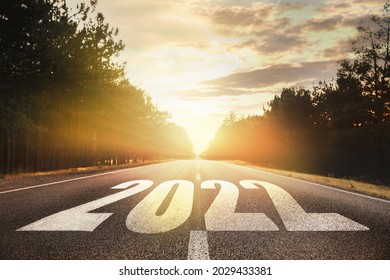 Start new year with fresh vision and ideas. 2022 numbers on asphalt road - Shutterstock ID 2029433381