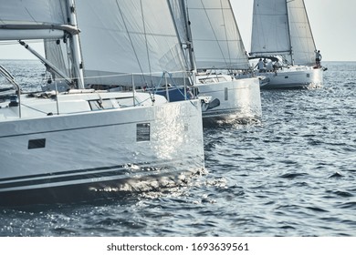 Start Of Race Of Sailing Regatta, Sailboats Compete In A Sail Regatta At Sunset, Sun Reflection On Board Of Boat, Clear Weather