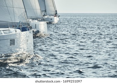 Start Of Race Of Sailing Regatta, Sailboats Compete In A Sail Regatta At Sunset, Sun Reflection On Board Of Boat, Clear Weather