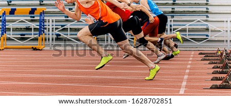 start sprint men runners run 100 meters at stadium