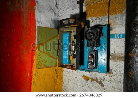 The start switch is a stop on the wall of an abandoned bunker. non-working electrical equipment