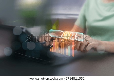 The Start Year 2026 button on the slider and chart. switches on and off to activate the function. A business growth analysis concept. a businesswoman points to touch the virtual start icon button. 