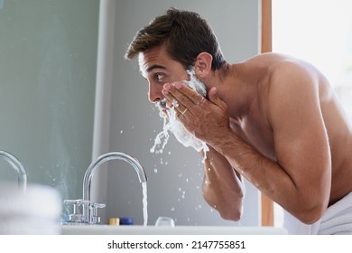 Start your day with a splash. Cropped shot of a handsome young man in his bathroom. - Shutterstock ID 2147755851