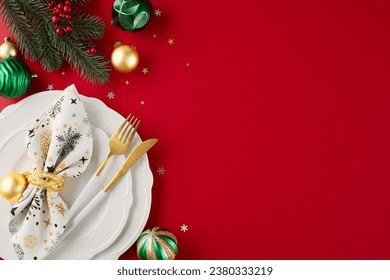 Start your holiday journey with Christmas table preparation. Top view flat lay of crockery, fir branches, ring napkin, holiday baubles, shiny confetti on red background with advert panel - Powered by Shutterstock