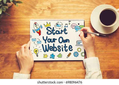 Start Your Own Website text with a person holding a pen on a wooden desk