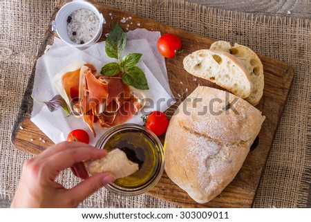 Starter - ham, ciabatta, tomato, basil, olive oil, rustic wood background, top view